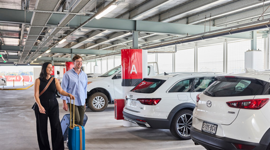 a male and female walking inside the Adelaide Airport Terminal Car Park