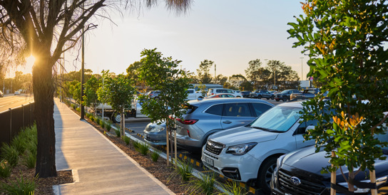 Three Adelaide Airport staff members are chatting in a car, while the driver parks at the staff parking.